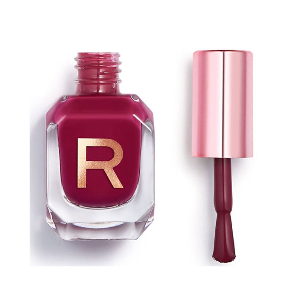 Fles donkerrode nagellak met applicator. Transparante glazen fles met gouden 'R'-opdruk en roségouden dop.