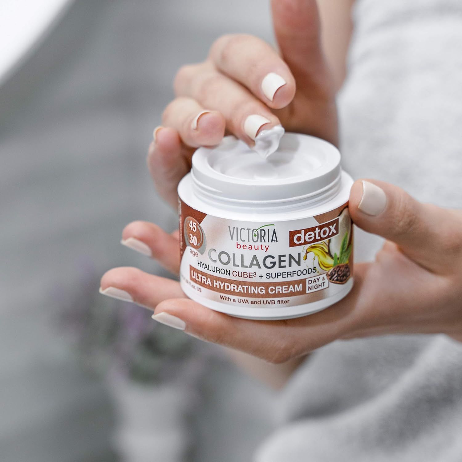 Victoria Beauty Collageencrème in een open pot, vastgehouden door handen.