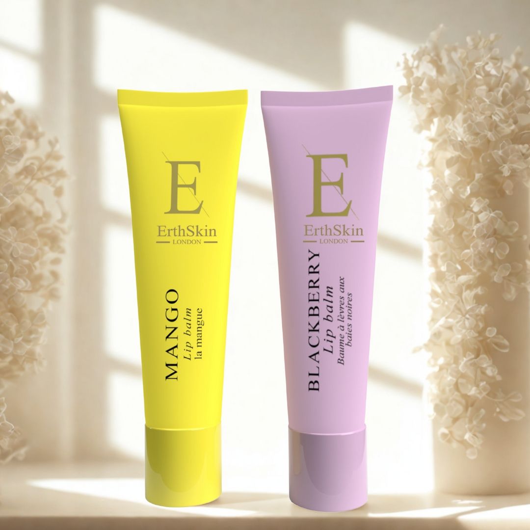 Twee ErthSkin lippenbalsem tubes: geel en lila. Opschriften: Mango, Blackberry. Achtergrond: wazige bloemen.