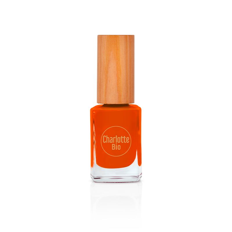 Flacon de vernis à ongles orange avec bouchon en bois. Le logo Charlotte Bio est visible sur le flacon.