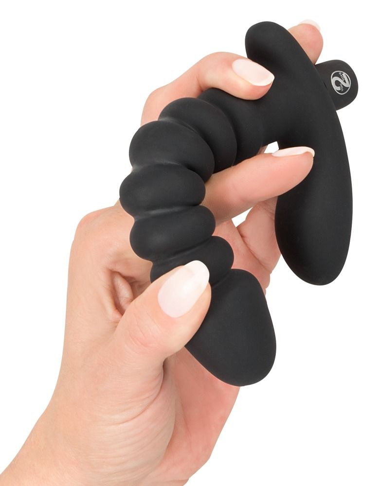 Hand die een zwarte vibrator vasthoudt, geribbelde schacht en gebogen handvat.