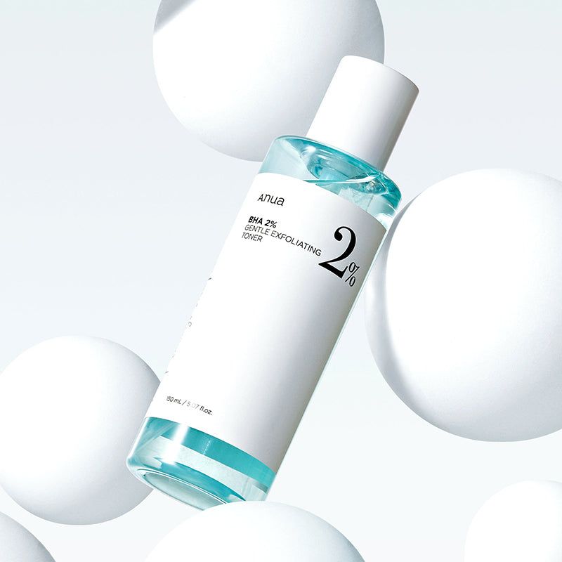 Tonerfles met wit label en blauwe inhoud, omringd door witte bollen. Opschrift: Anua BHA 2% Gentle Exfoliating Toner.