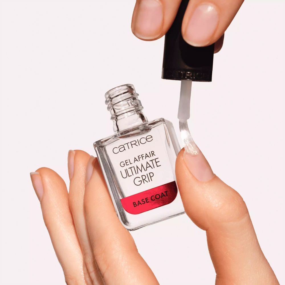 Catrice Gel Affair Ultimate Grip Base Coat wordt op een nagel aangebracht. Fles en borstel zichtbaar.