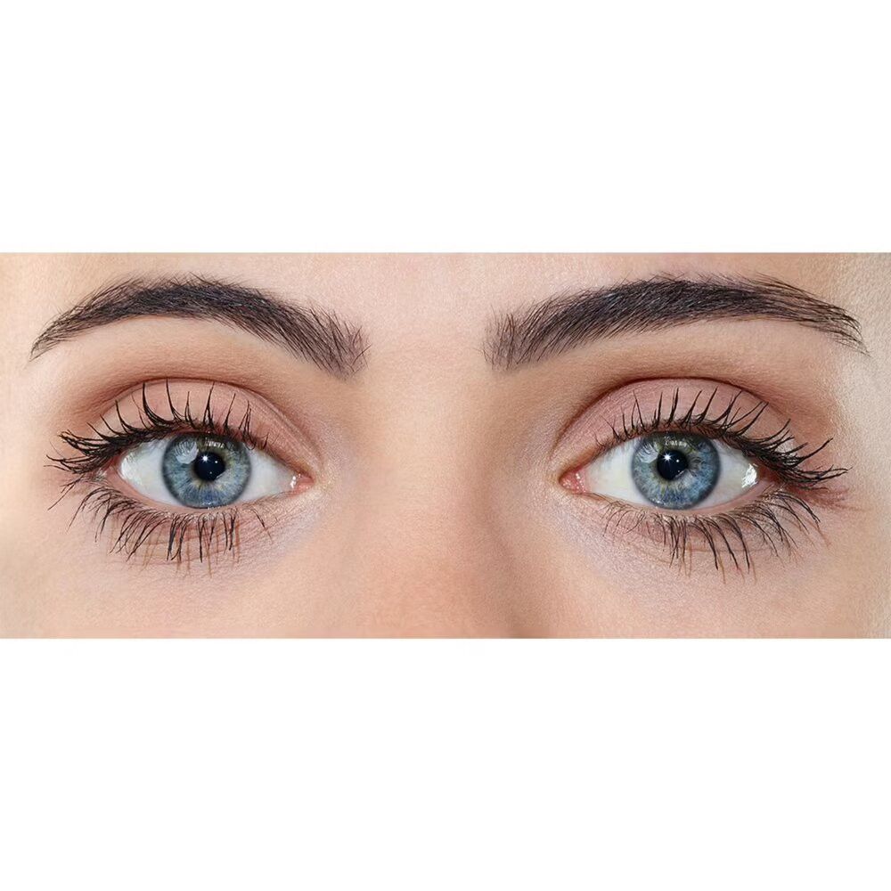 Gros plan sur deux yeux bleus avec des cils maquillés. Les sourcils sont visibles.