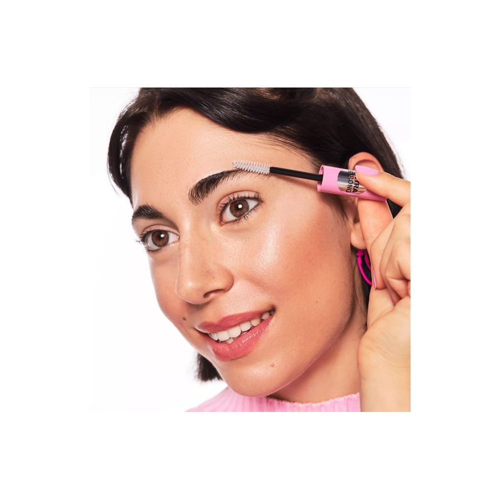 Vrouw met wenkbrauwgel applicator. Roze tube, zwarte borstel. Producttoepassing.