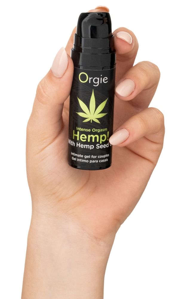 Hand houdt zwarte fles met groen cannabisblad en tekst: Intense Orgasm Hemp! Intieme gel voor koppels. Merk: Orgie.