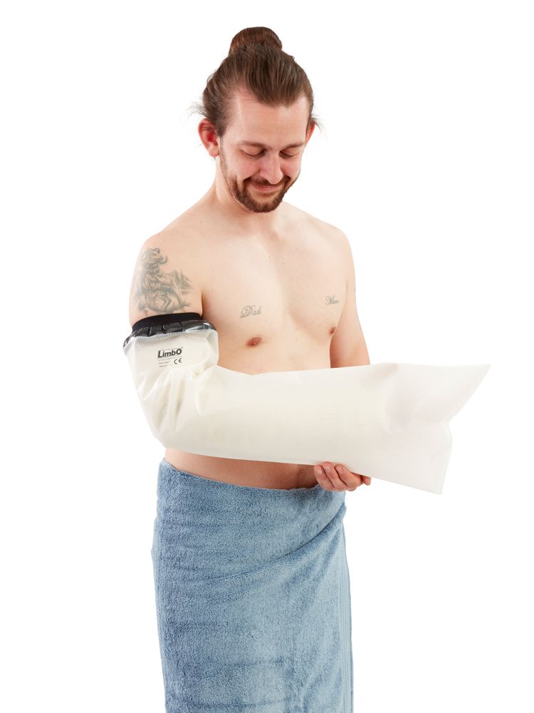 Homme avec protection de bras. La protection est fixée au bras. L'homme est couvert d'une serviette.
