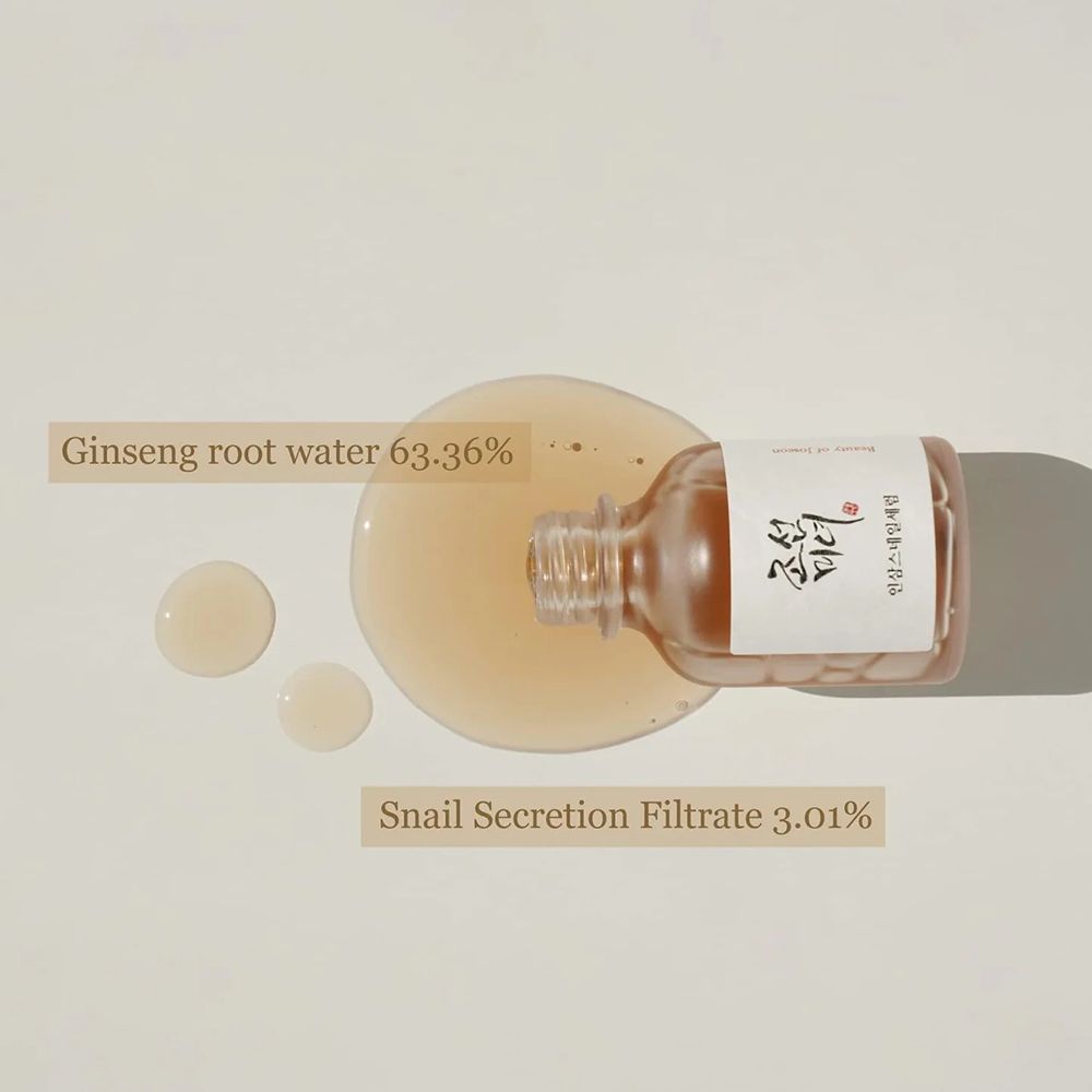 Transparante fles met serum en druppels. Etiket met Koreaanse tekst. Ginseng root water 63.36%. Snail Secretion Filtrate 3.01%.