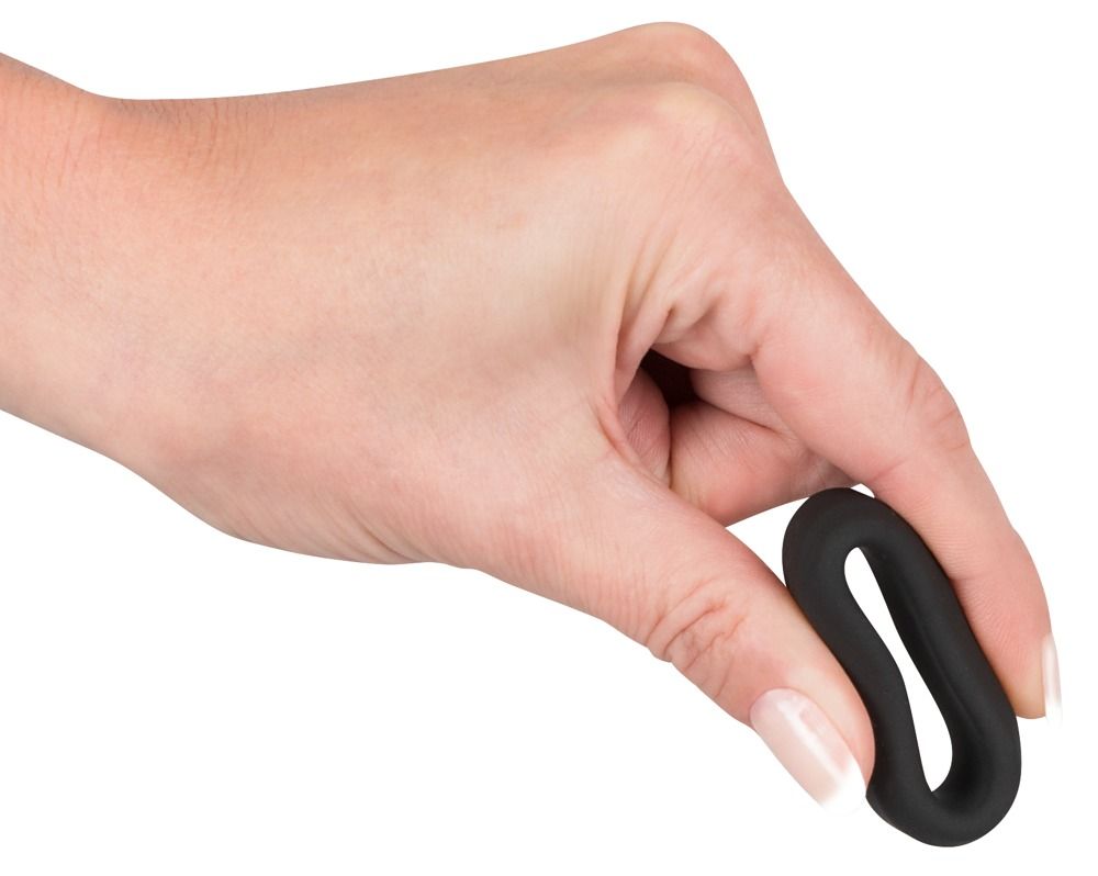 Anneau noir flexible en silicone tenu par une main.