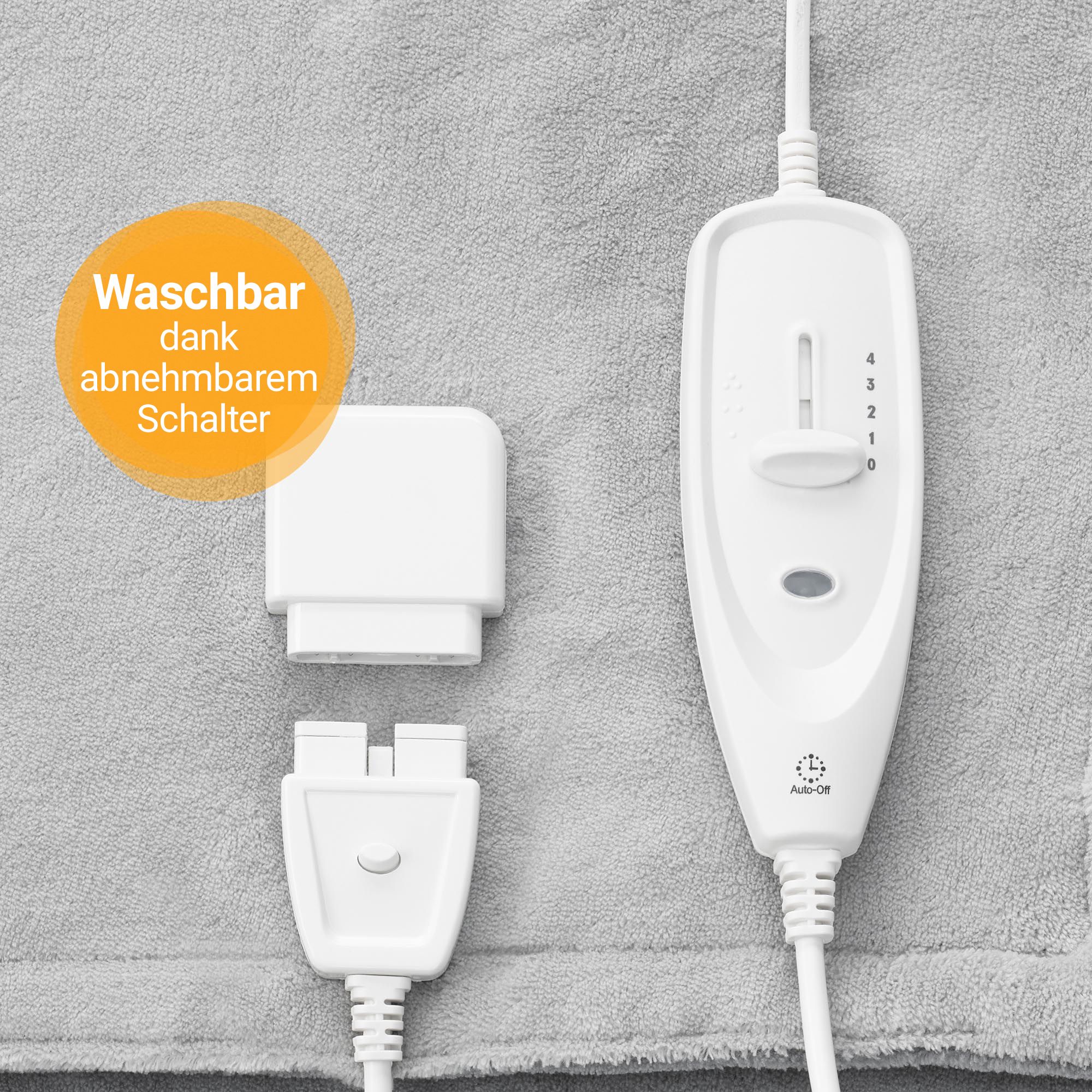 Close-up van het afneembare bedieningselement en de connector van een grijze verwarmingsdeken.