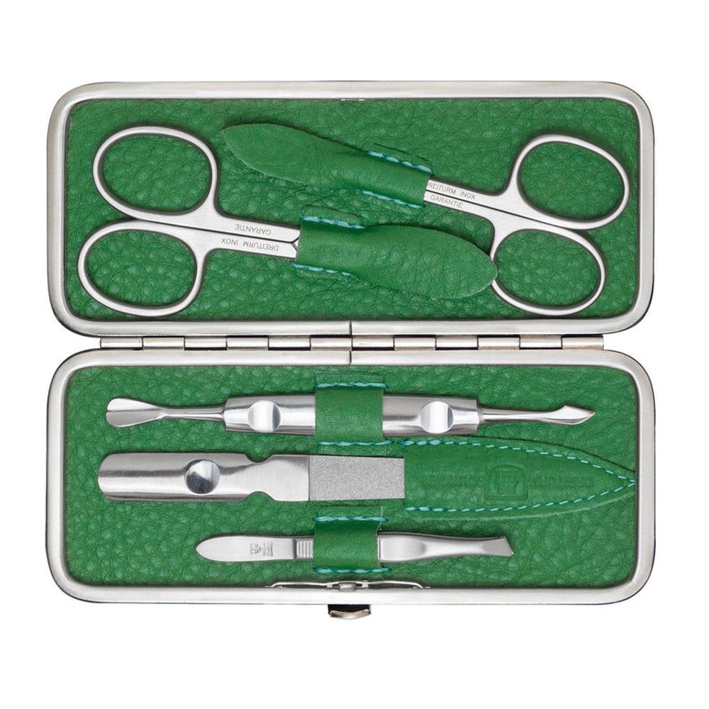 Coffret manucure vert ouvert. Ciseaux, pince à épiler, lime à ongles et autres instruments. Métal et cuir.