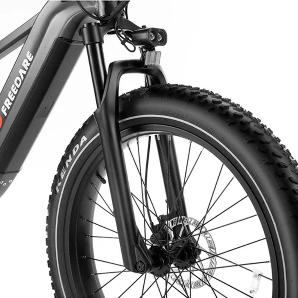 Gros plan de la fourche avant et du pneu d'un vélo électrique noir. Pneus Kenda.