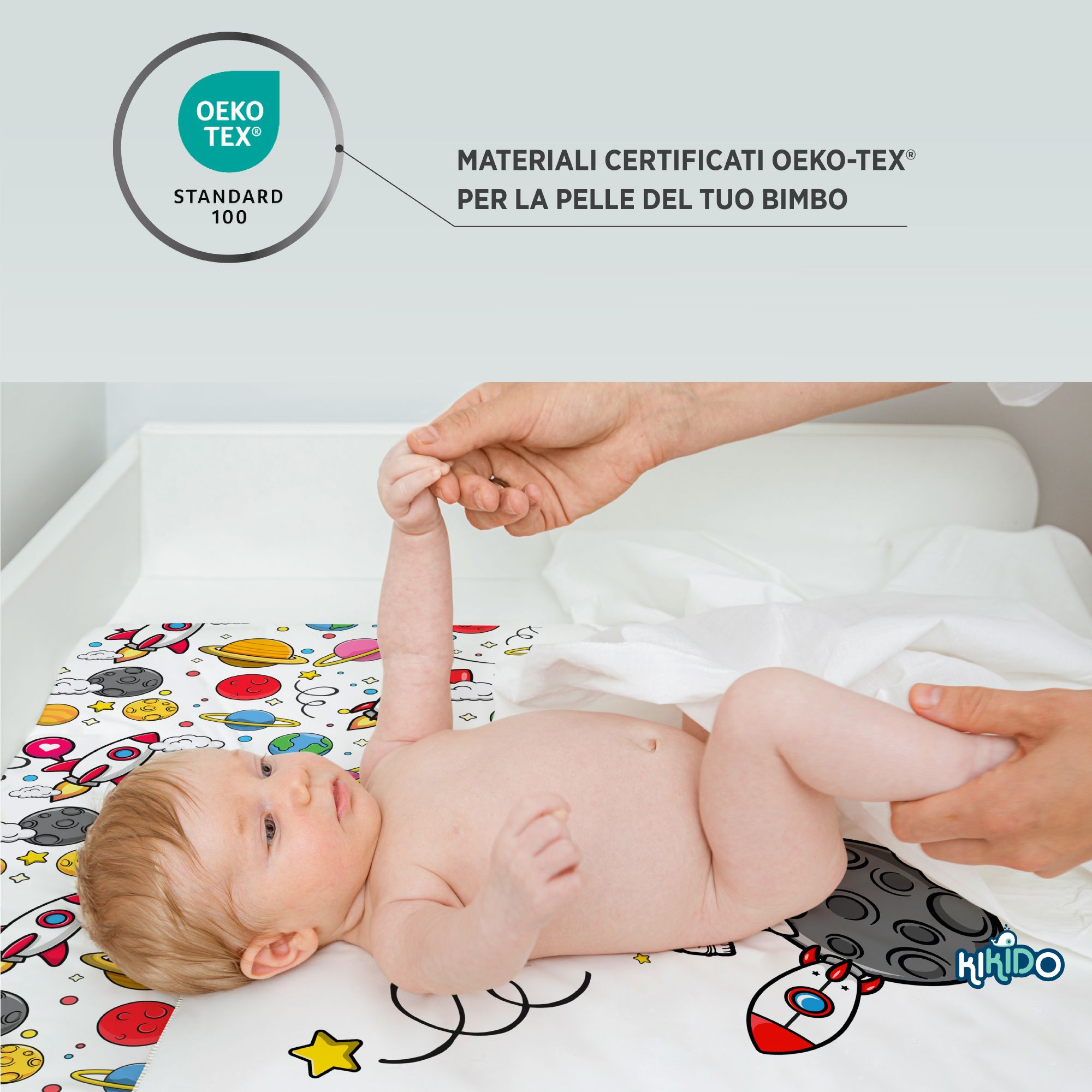 Baby op aankleedkussen met ruimtevaartmotief. Oeko-Tex Standard 100 certificering. Kikido logo.