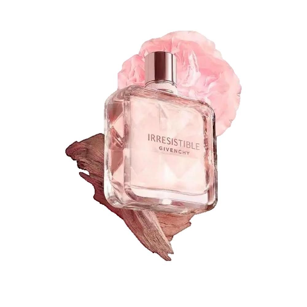 Flacon de parfum avec contenu rose. Inscription: Irresistible Givenchy. Flacon carré avec contenu rose. Avec bois et fleur rose.