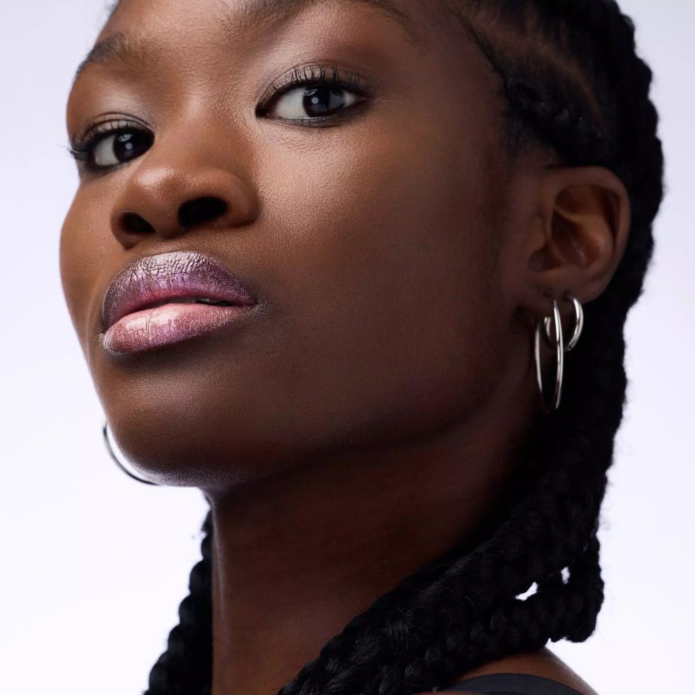 Close-up van een persoon met lipgloss. De lippen zijn glanzend en roze.