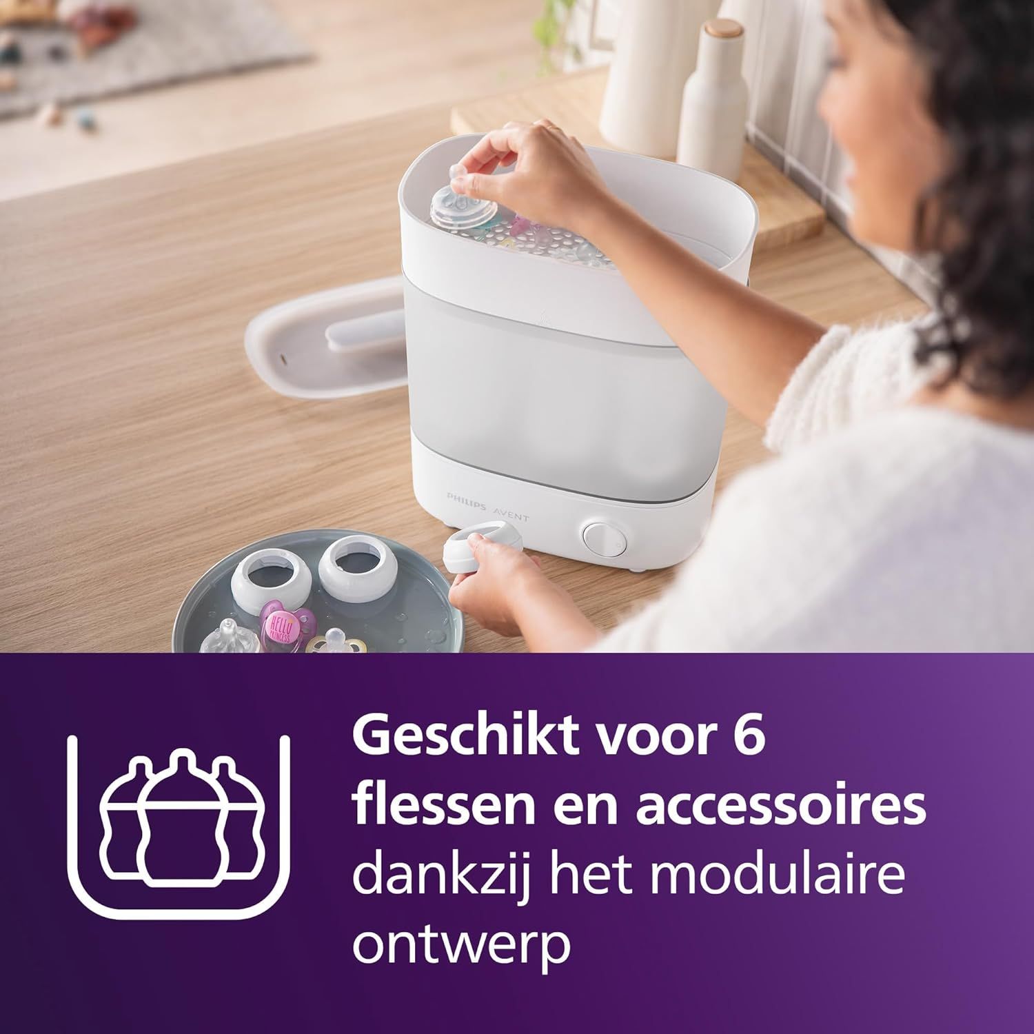 Een hand plaatst babyflessen in een Philips Avent sterilisator, met een paars symbool voor 6 flessen.