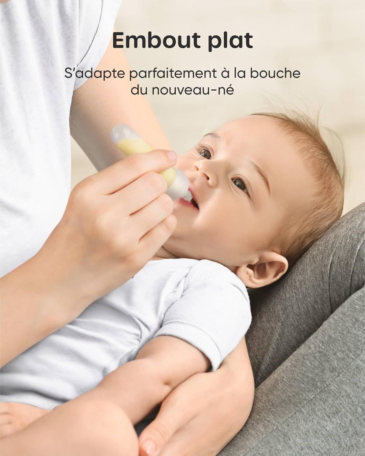 Un bébé reçoit un médicament d'un distributeur jaune et transparent avec embout plat.