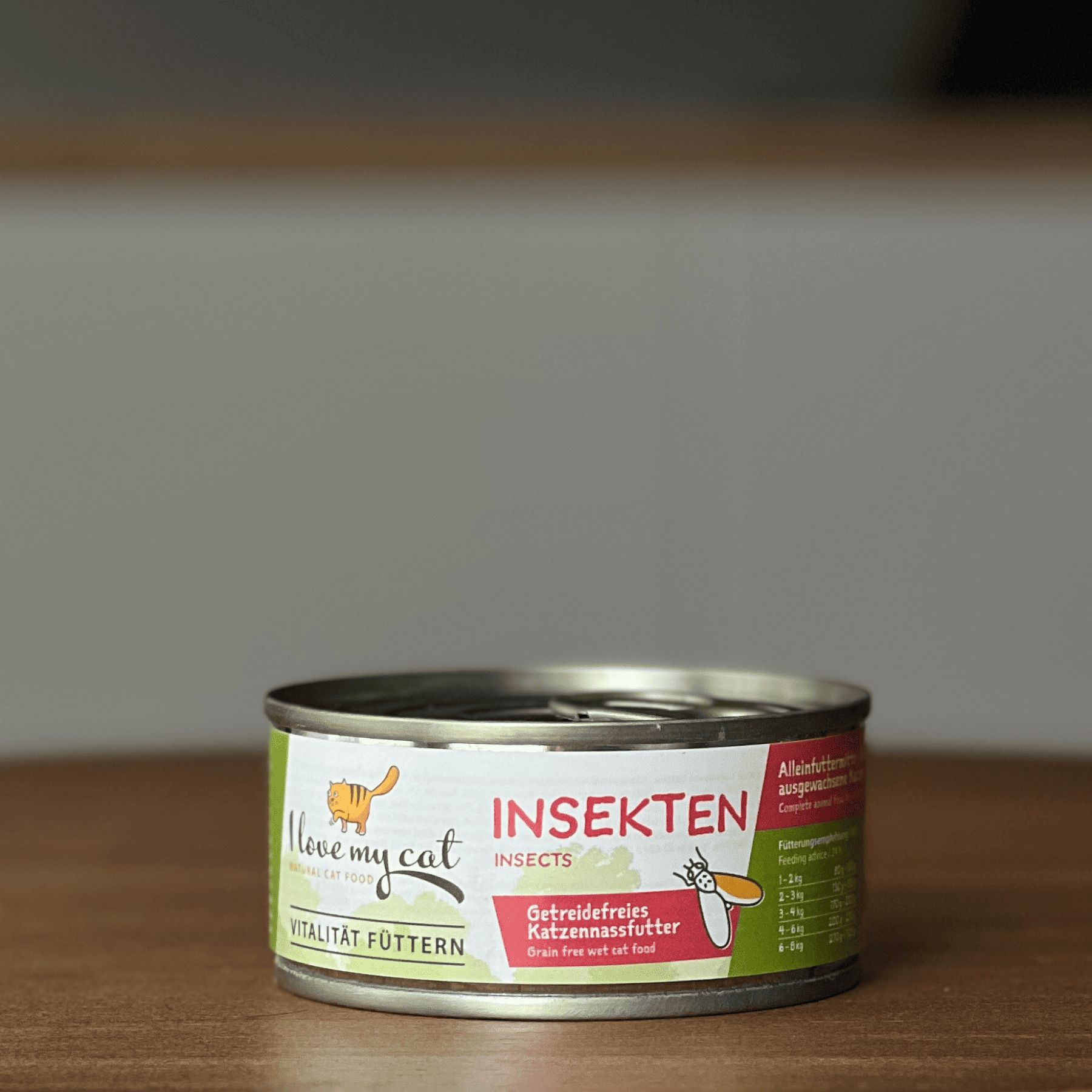 Boîte de nourriture pour chats avec étiquette verte. Inscription : I love my cat, Insekten. Nourriture pour chats sans céréales. Boîte devant fond flou.
