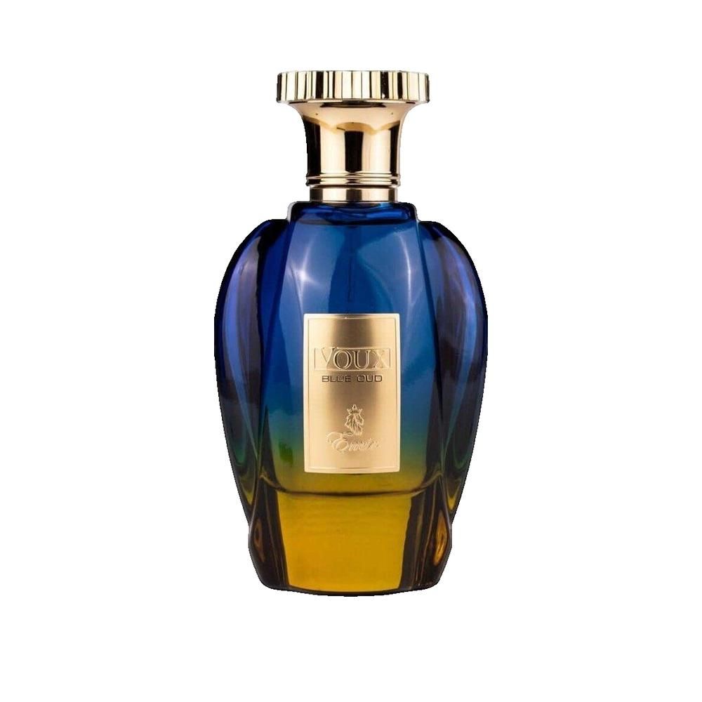 Flacon de parfum bleu-jaune avec bouchon doré. Inscription : Voux Blue Oud. Flacon avec détail doré.