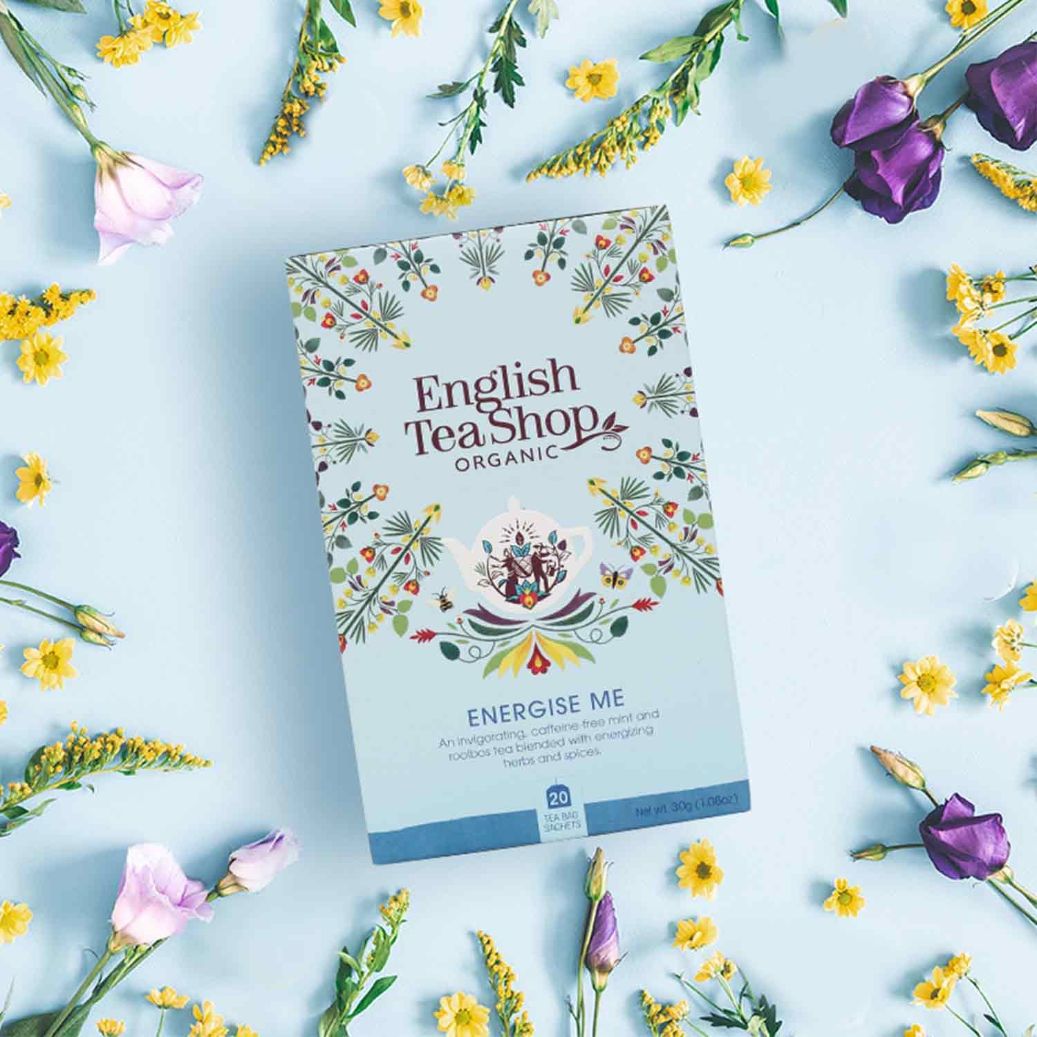 Theedoos English Tea Shop ORGANIC, ENERGISE ME, BIO, omringd door bloemen.