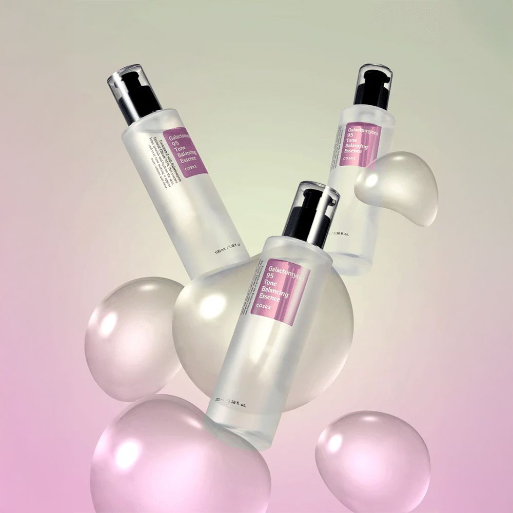 Trois bouteilles de Galactomyces 95 Tone Balancing Essence flottant parmi des sphères.