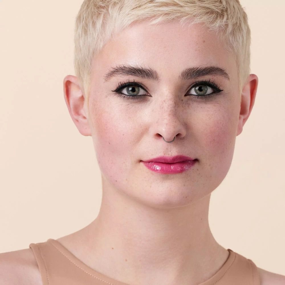 Portret van een vrouw met blond haar. Ze draagt roze lipolie.