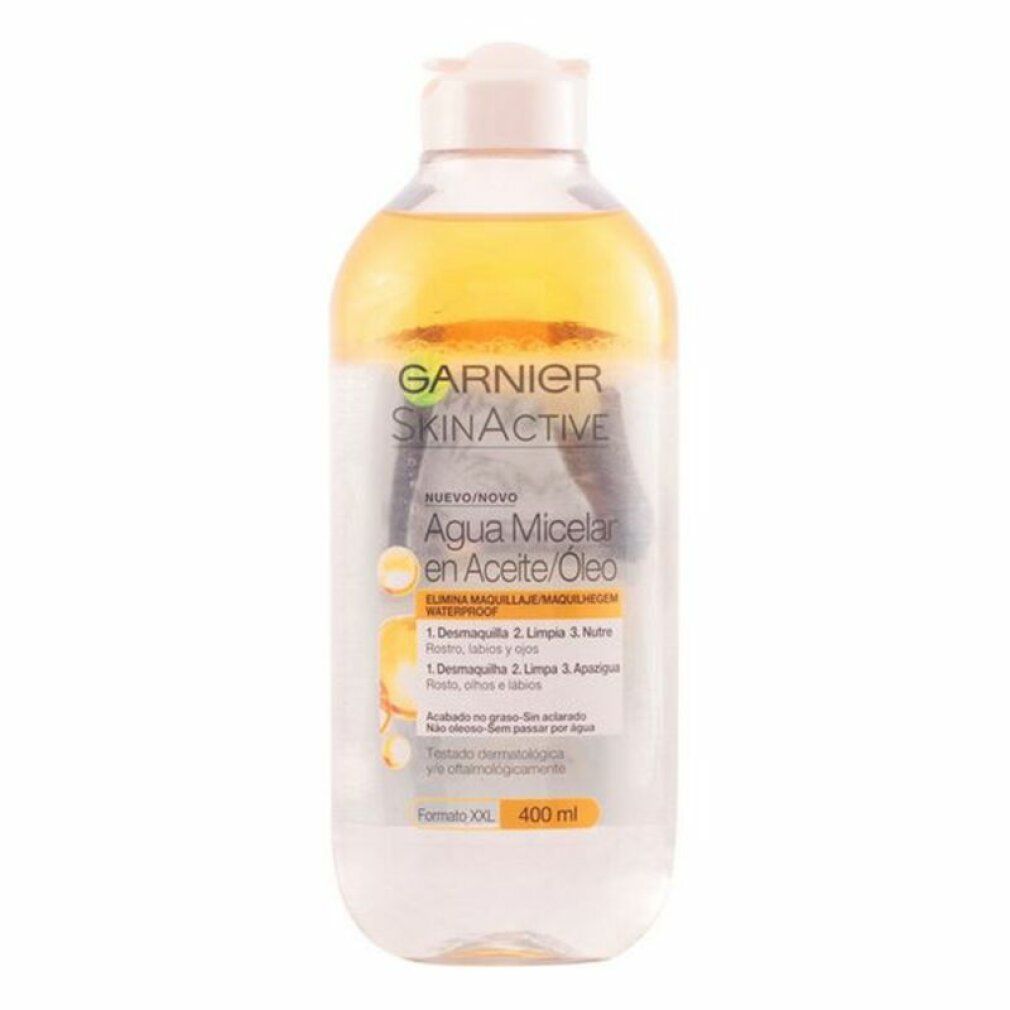 Transparante fles met gele vloeistof en witte dop. Opschrift Garnier SkinActive, Agua Micelar en Aceite/Óleo. 400 ml.