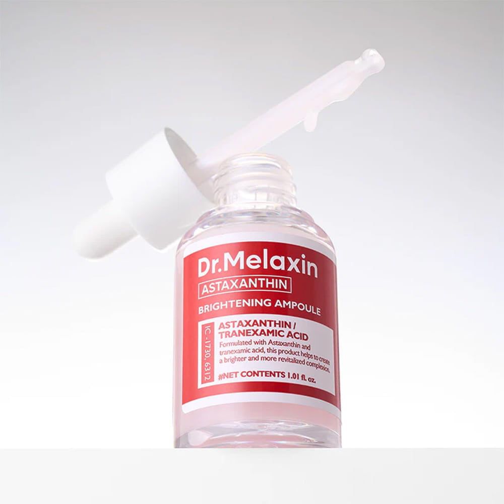 Flacon en verre transparent avec bouchon blanc et étiquette rouge. Compte-gouttes dans le goulot. Texte: Dr. Melaxin, Astaxanthine, Brightening Ampoule.