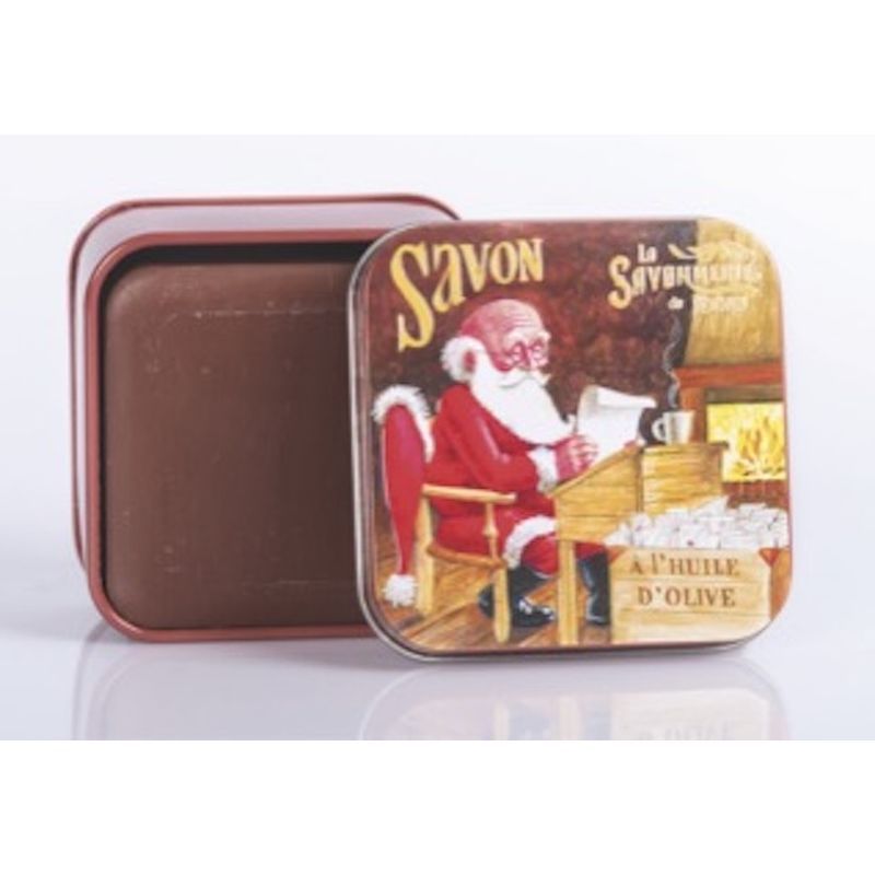 Metalen doos met zeep. Deksel met kerstman illustratie. Bruine zeep in geopende doos.