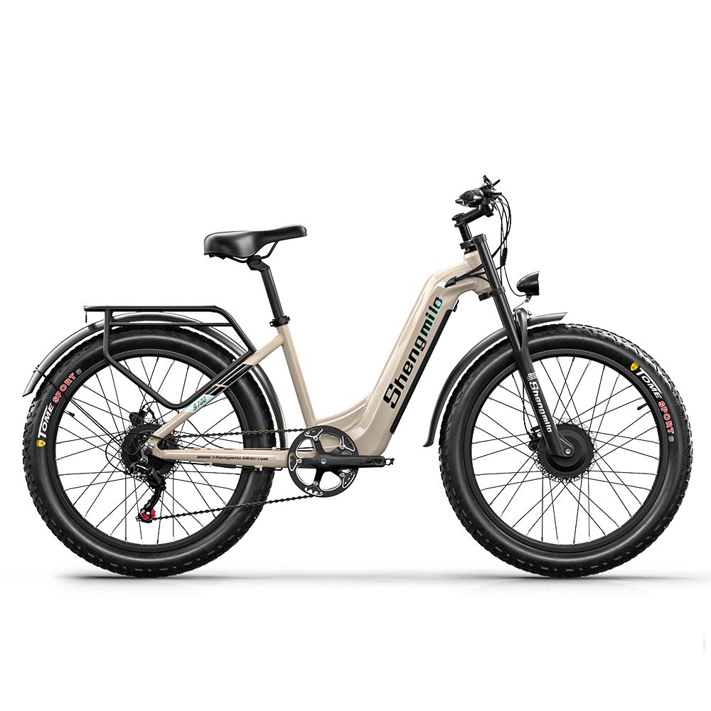E-bike, vue latérale. Cadre beige, pneus noirs. Marque Shengmilo visible. Porte-bagages et garde-boue.