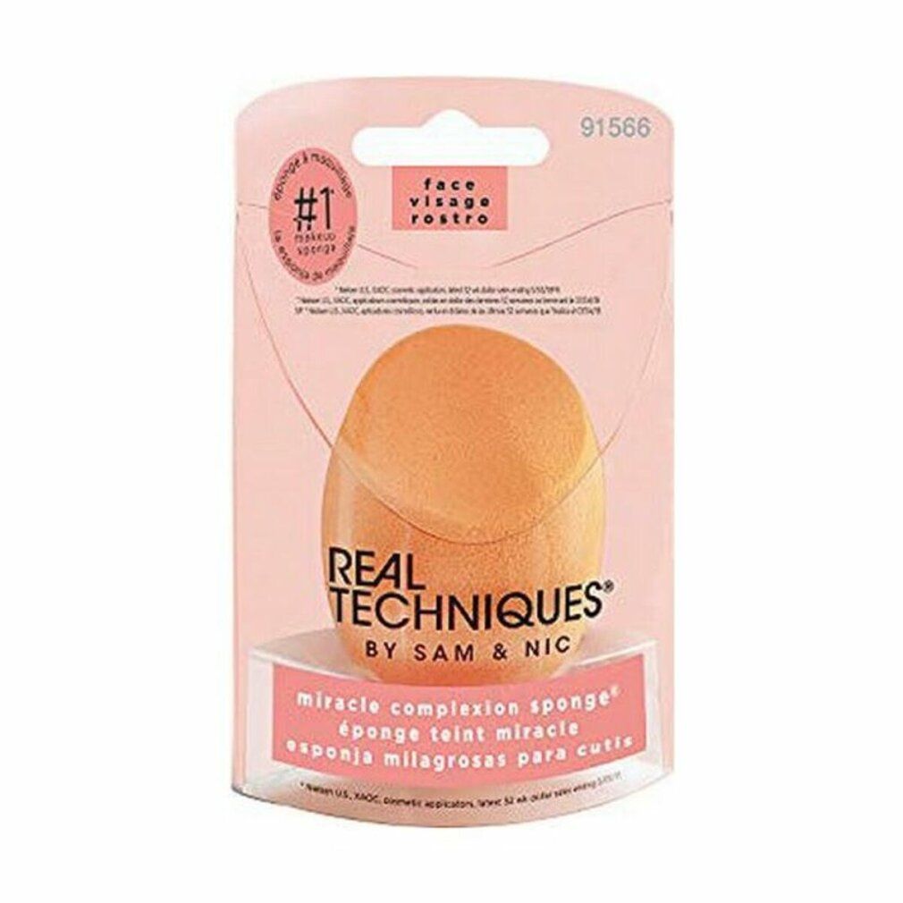 Verpakking met een oranje make-upspons. Er staat 'REAL TECHNIQUES' en 'MIRACLE COMPLEXION SPONGE' op.