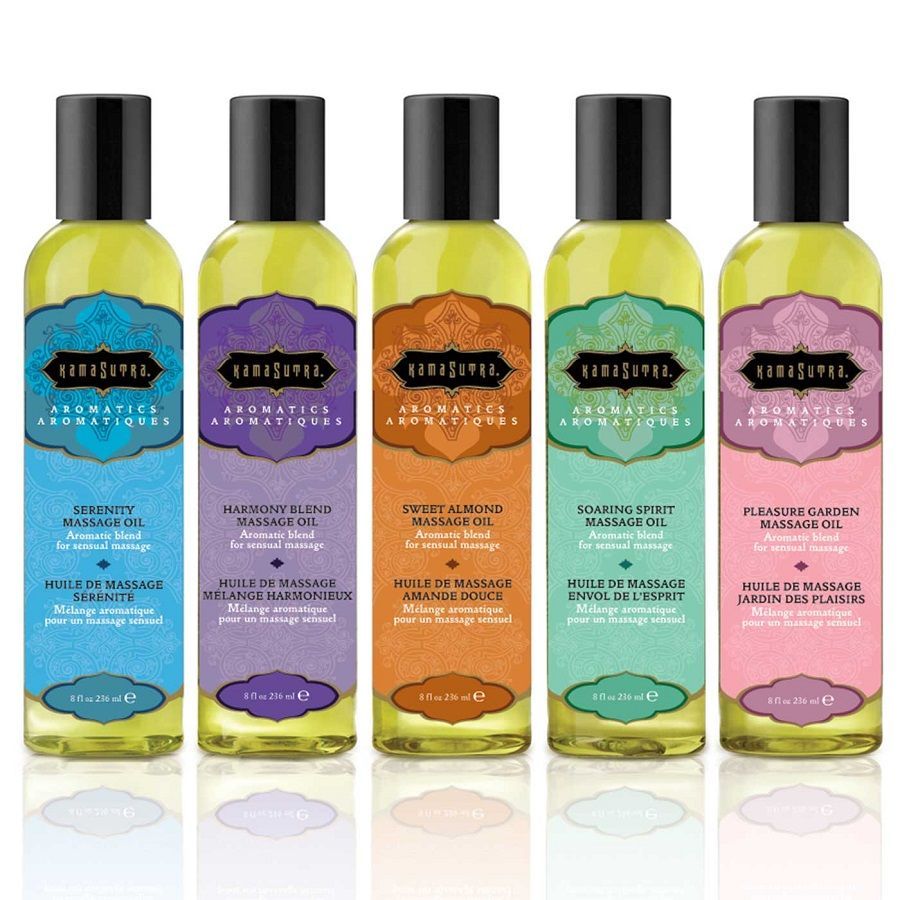 Cinq bouteilles d'huile de massage Kamasutra Aromatics dans différents parfums et couleurs, toutes avec un bouchon noir.