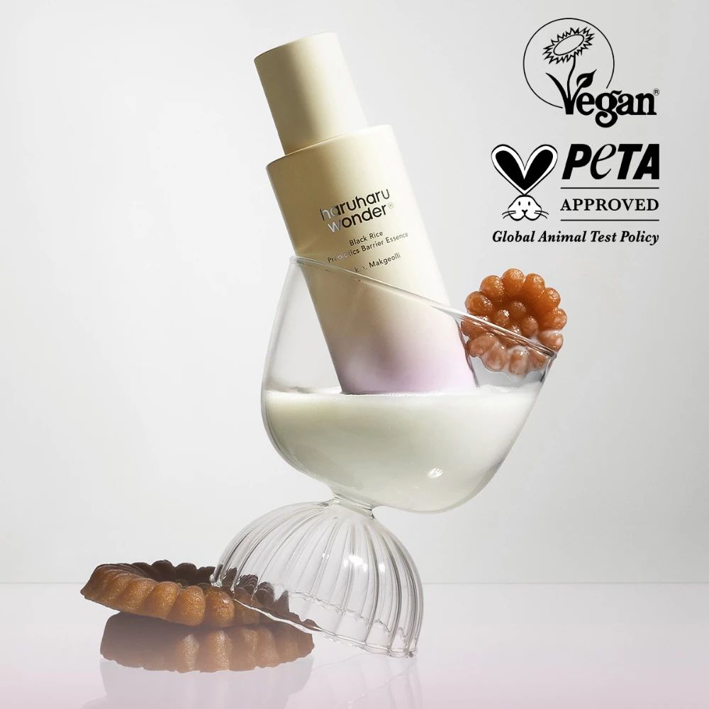 Fles in een glas met melk en decoratie. Vegan- en PETA-keurmerk.