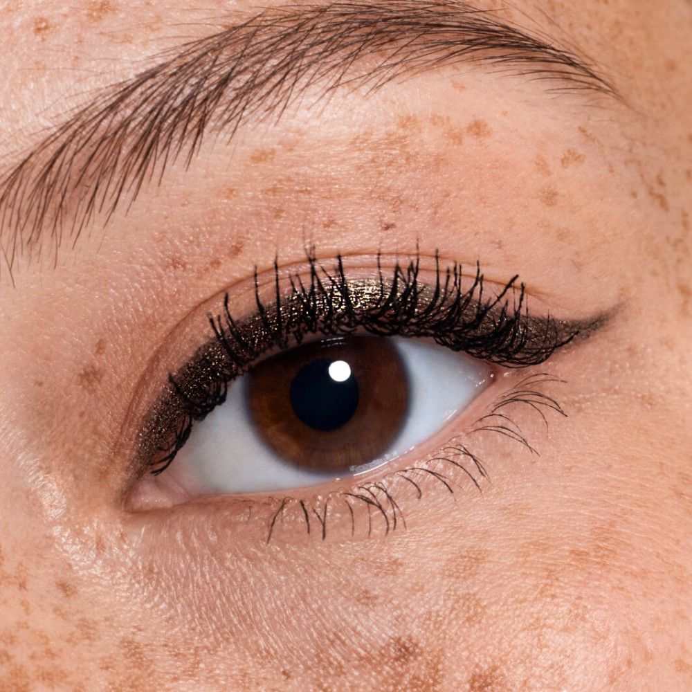 Close-up van een oog met eyeliner en mascara. Sproeten.