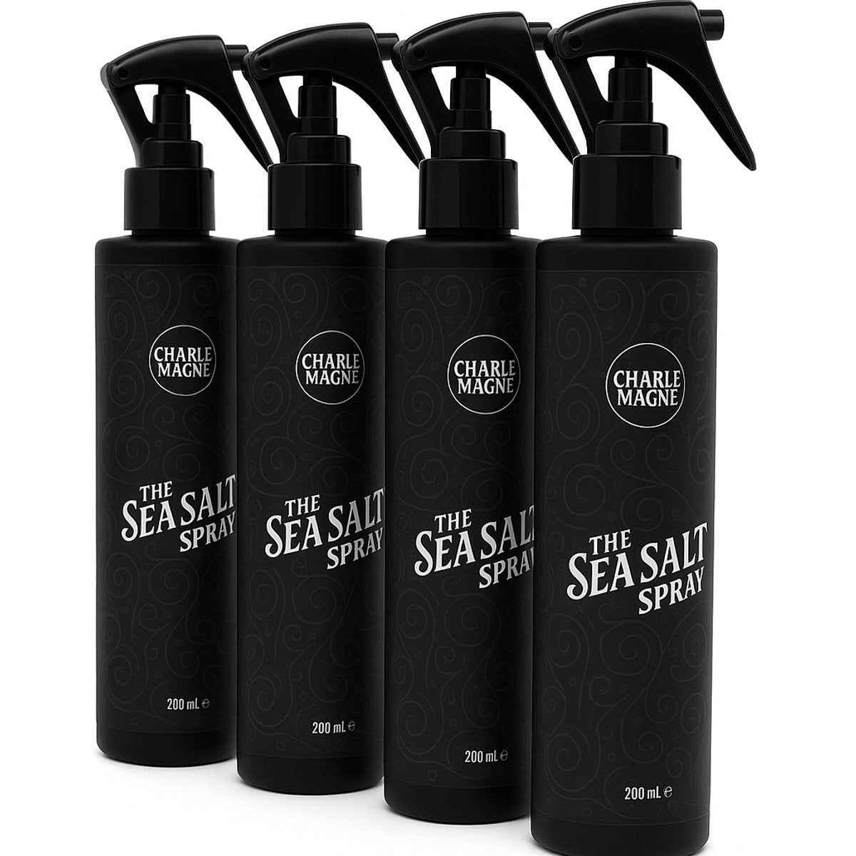 Vier zwarte spuitflessen. Op elke fles staat "CHARLE MAGNE" en "THE SEA SALT SPRAY". Elke fles heeft een zwarte spuitkop.