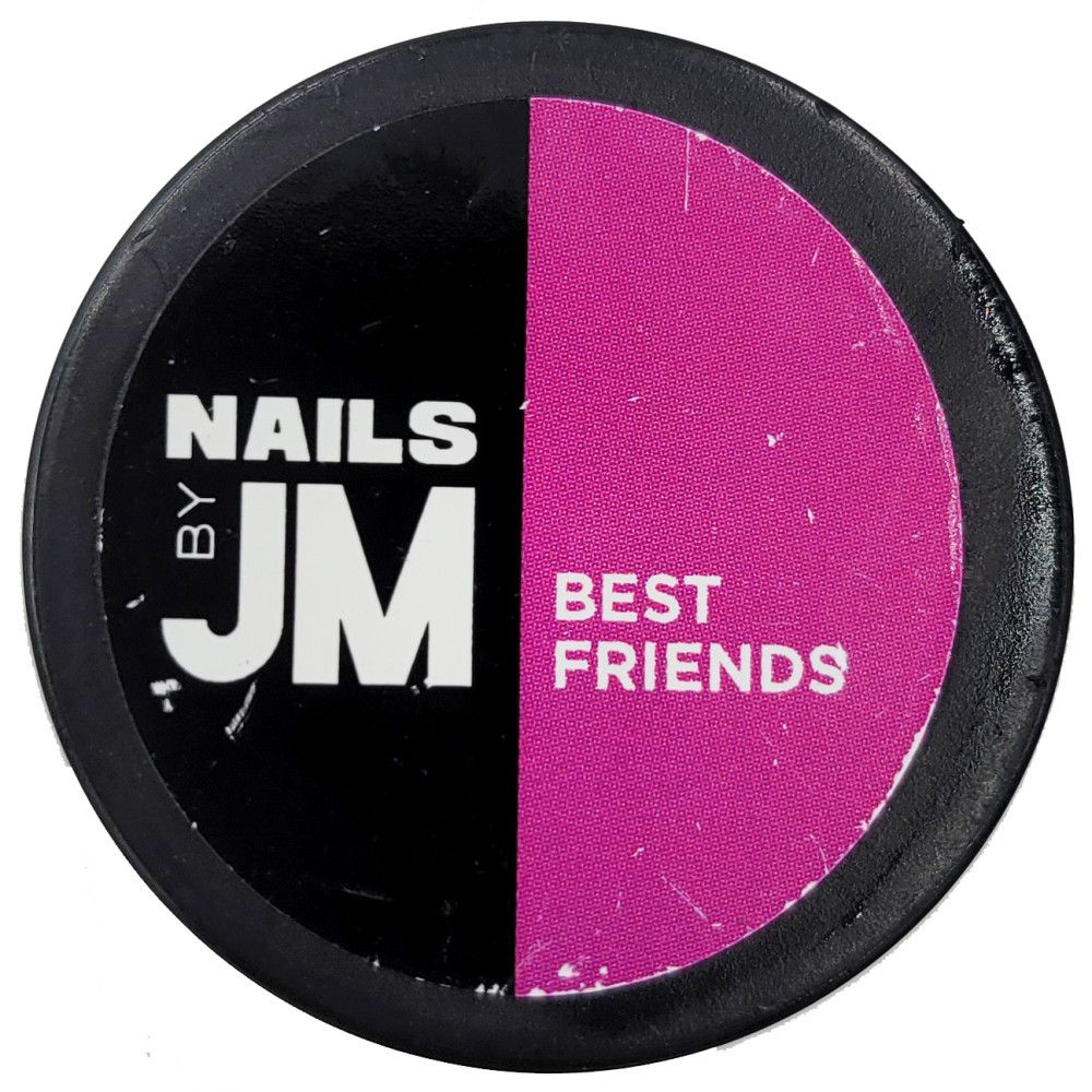 Contenant rond, divisé en noir et rose. Sur le noir, "NAILS BY JM". Sur le rose, "BEST FRIENDS".