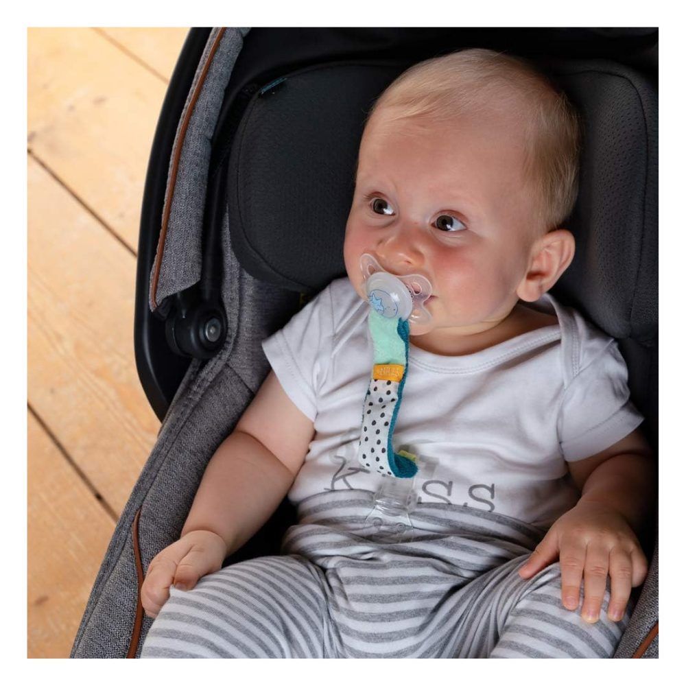 Baby met speen en speenketting Minze in autostoel. Baby draagt shirt met opdruk.