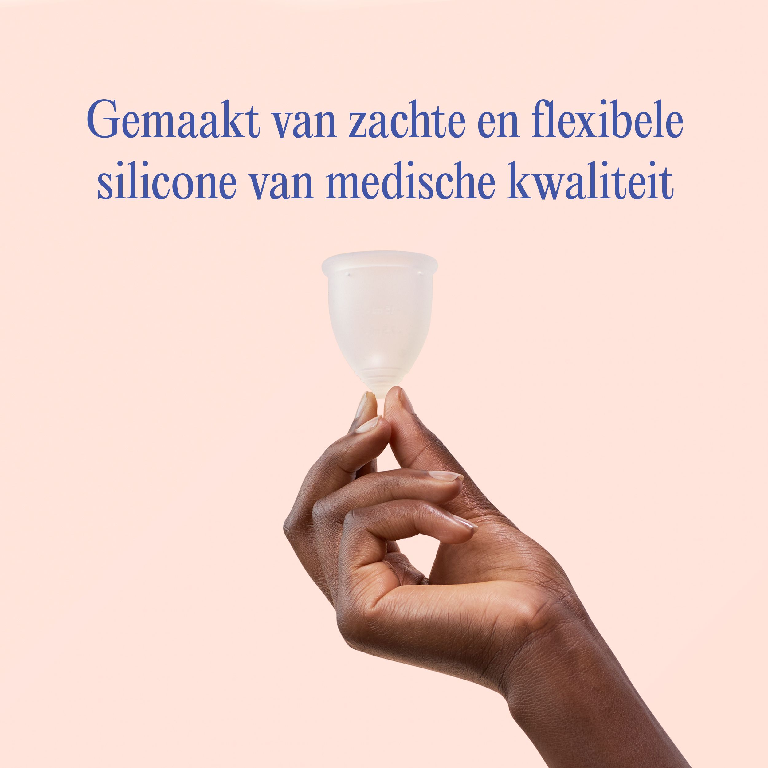 Een hand houdt een doorschijnende menstruatiecup van medisch siliconen vast.