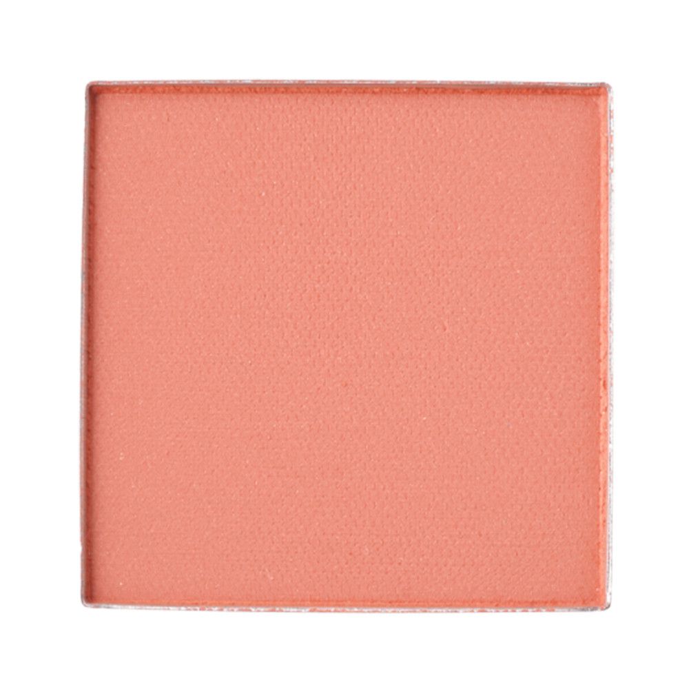 Poudre de fard à joues corail carrée dans une coupelle argentée.