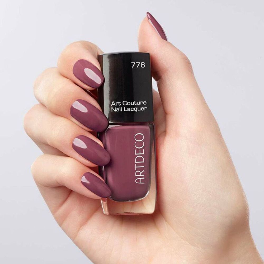 Une main tient une bouteille de vernis à ongles Artdeco Art Couture. Les ongles sont vernis avec le même vernis.