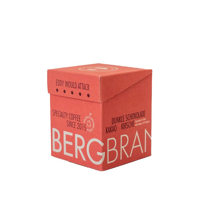 Emballage rouge. Inscription : BERGBRAND, Eddy would Attack, Kapselkaffee. Texte : Chocolat noir, cacao, cerise.