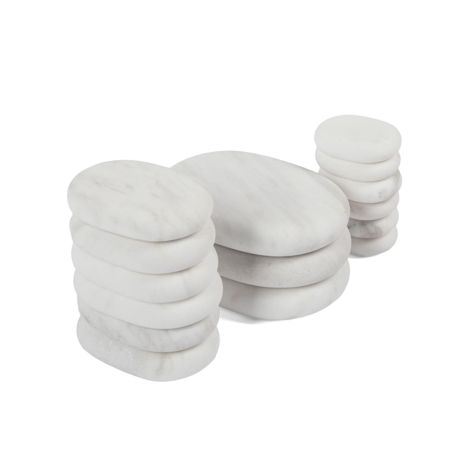 Verschillende witte, ovale stenen in stapels gerangschikt. Op witte achtergrond.