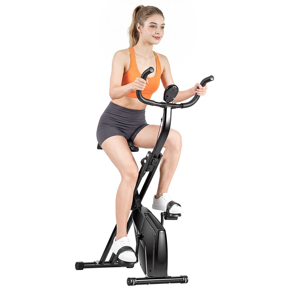 Femme sur vélo d'appartement pliable noir. Vêtements de sport. Le vélo a un écran.
