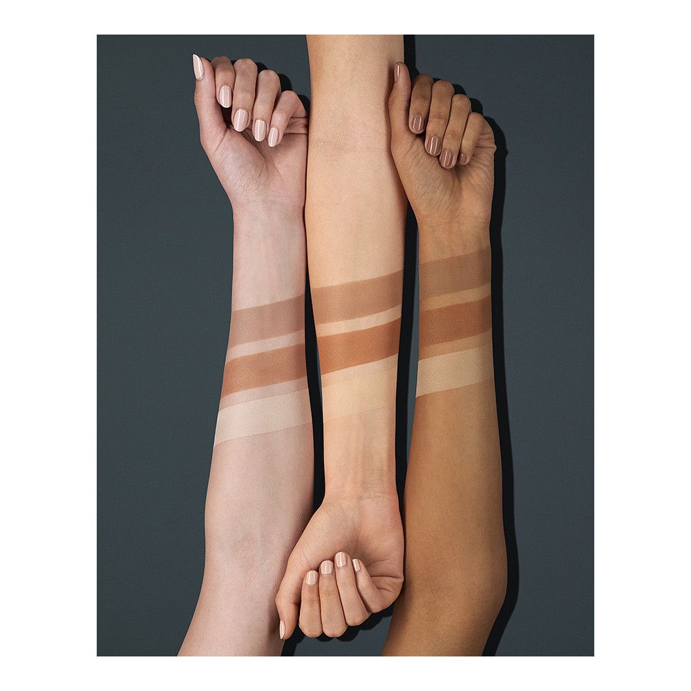 Trois bras avec teintes de contouring appliquées. Différents tons de peau montrent la sélection de couleurs. Fond sombre.