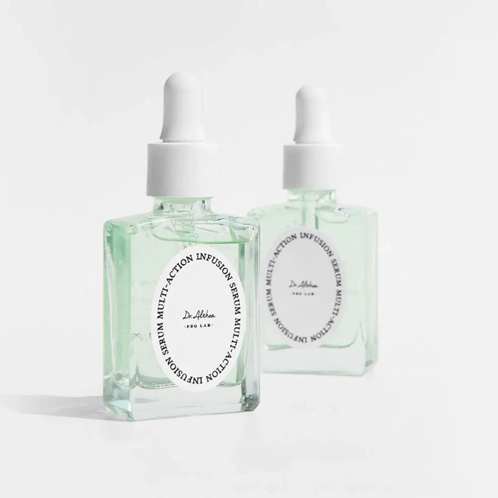 Deux flacons de sérum avec bouchons et étiquettes blancs. Liquide vert visible.