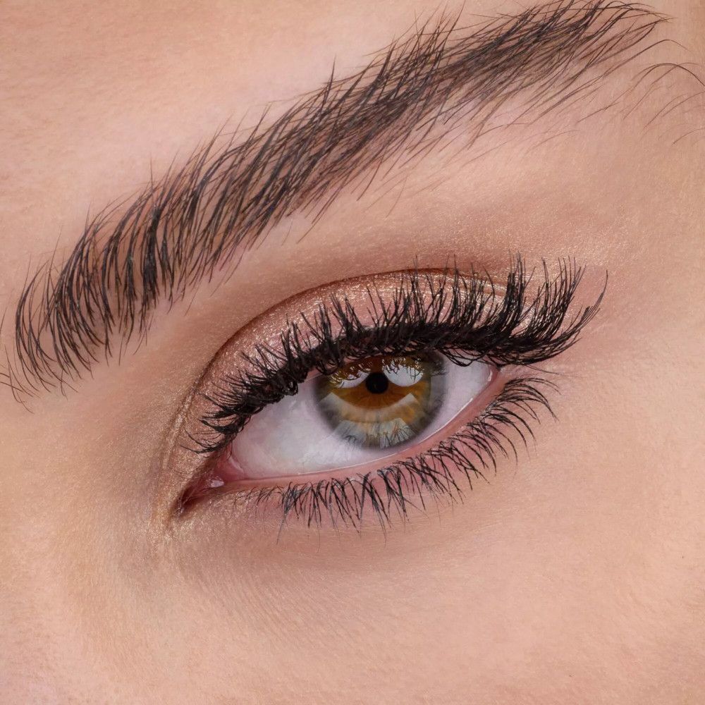 Close-up van een oog met mascara en goudkleurige oogschaduw.