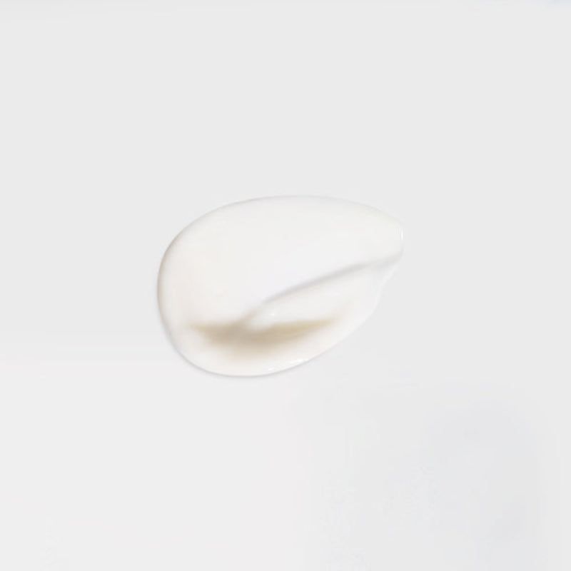 Klodder oogcrème op witte achtergrond.