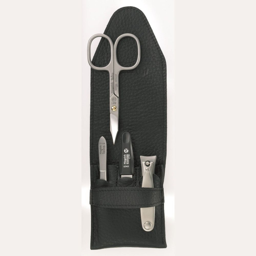Zwart leren etui met manicure set. Bevat schaar, nagelvijl, nagelknipper en huidtang. Merk Niegeloh Solingen.