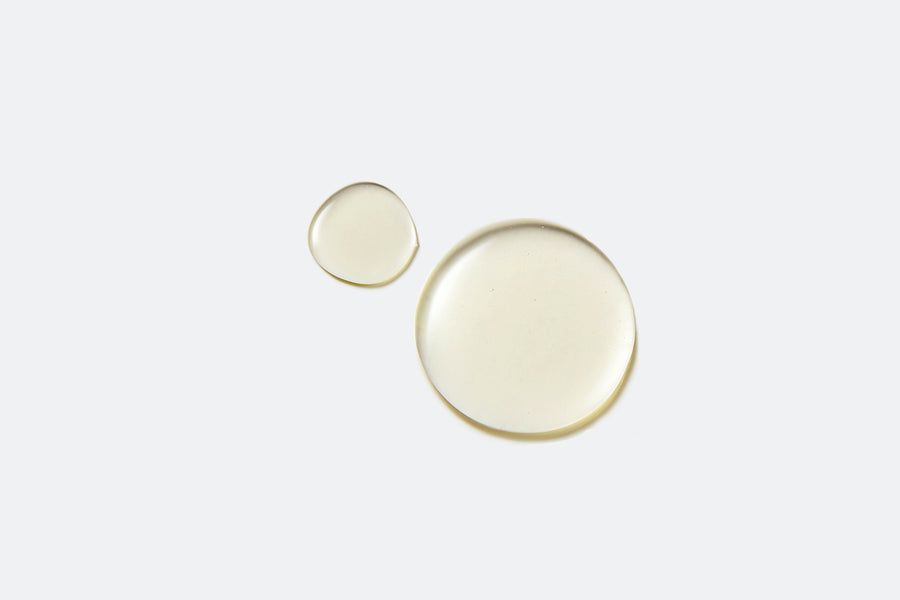 Twee druppels vloeistof op witte achtergrond. Een grote en een kleine druppel.