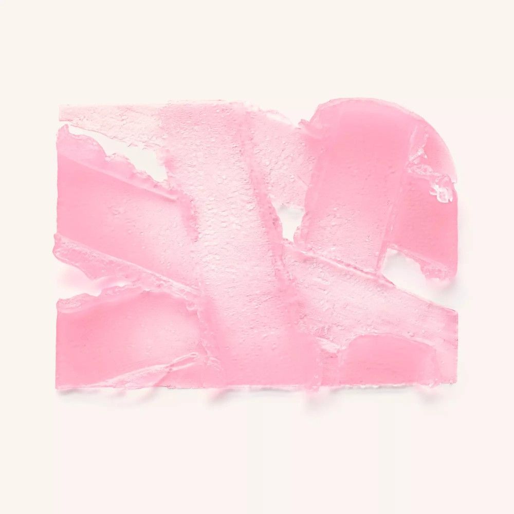 Taches de couleur rose sur fond clair. Texture du produit visible.